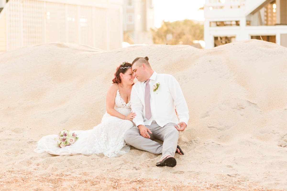 Outer Banks Vow Renewal Couple sitting on beach looking into each other's eyes