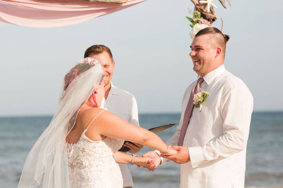 Outer Banks Wedding Ceremony with Officiant and Couple holding hands smiling